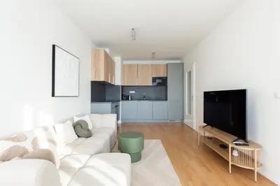 a living room with a white couch and a flat screen tv at Fresh All-in Apartment Prague in Prague