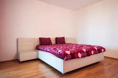 a bedroom with a bed with a pink comforter at Cosy and spacious apartment with the view to the garden in Prague