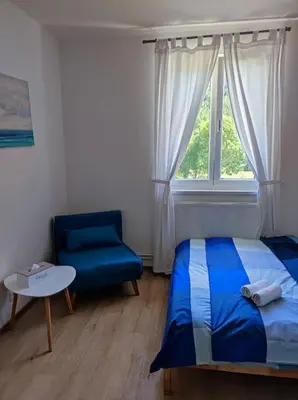 a bedroom with a bed and a chair and a window at Lávka 222 Chocerady in Chocerady