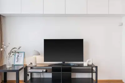 a television on a black stand in a living room at REAL Living by REFA Karlin 307 in Prague