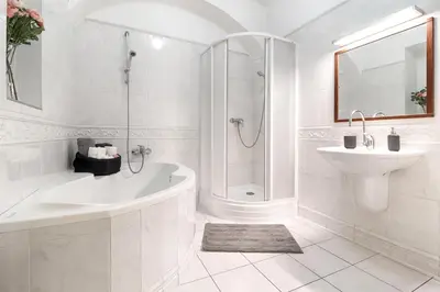 a white bathroom with a tub and a sink at Luxury Karmelitska 2B apartment in Prague