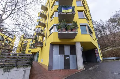 a yellow building with potted plants on it at Apartmán u parku Parukářka in Prague