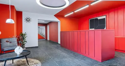 a living room with red walls and a table at TERRACE-VIEW PRAGUE STUDIOS for Business & Leisure, FREE PARKING, Near Metro, Gym in Prague