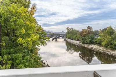 a view of a river with a bridge in the background at Central Prague Residence Karlín in Prague