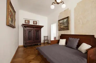 a bedroom with a bed and a cabinet in it at Dlouhá Art & Antique Stay in Prague