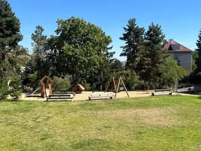 a playground with benches in a park with trees at Apartment Sport & Sauna Prague in Prague