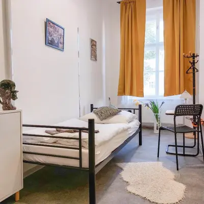 a bedroom with a bed and a chair and a window at Single room B5 centre of Prague in Prague