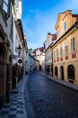 a cobblestone street in a city with buildings at Pokoj v Pražských Holešovicích C1 in Prague