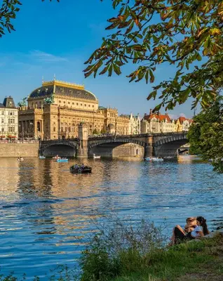 a bridge over a river in front of a building at Pokoj v Pražských Holešovicích C1 in Prague