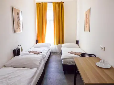 a room with three beds and a table and a window at Two-room apartment near the center F2 in Prague