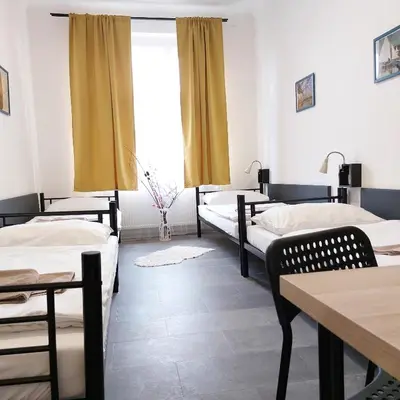 a room with three beds and a table at Traveller's room F1 u výstaviště in Prague