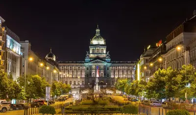 a large building with a clock tower at night at Traveller's room F1 u výstaviště in Prague