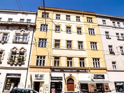 a large yellow building on a street with cars parked in front at Prague room Letná H2 in Prague