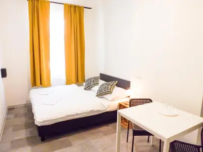a small room with a bed and a table at Letní pokoj na Pražské Letné H5 in Prague