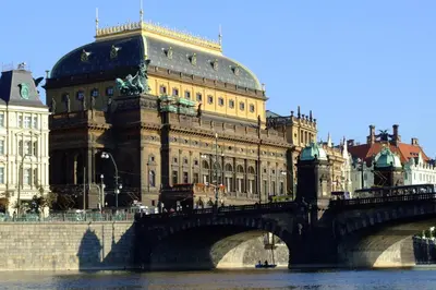 a bridge over a river in front of a building at Útulný podkrovní pokoj R4 v Praze in Prague