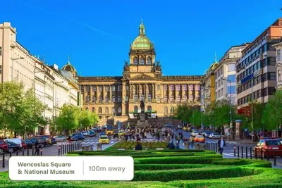 a large building with a clock tower in a city at HOMELY l 5 min to Airport Express,Train Station with self check in in Prague