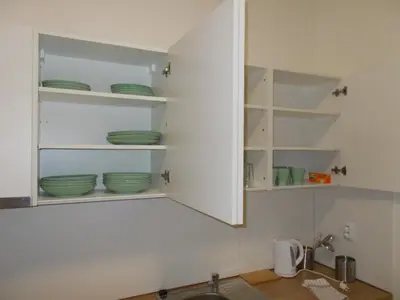 a kitchen with white cabinets with green dishes in it at Top Wenceslas Square Apartment in Prague