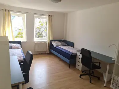 a room with two beds and a desk in it at Rodinný dům v Praze s bazénem in Prague