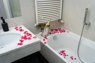 a bathroom with pink flowers on a counter next to a tub at Deluxe Rabbit Suite in Prague