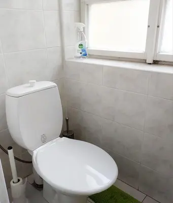 a white toilet in a bathroom with a window at Just 3 min Walk Old Town Center private room E in Prague
