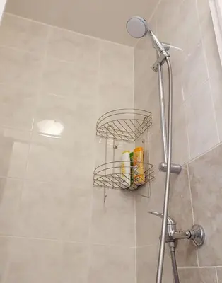 a bathroom with a shower with a rack of toiletries at Just 3 min Walk Old Town Center private room D in Prague