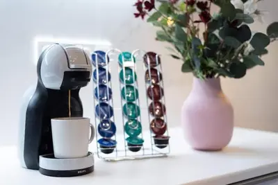 a table with a coffee maker and a vase with flowers at New Town 2 BDR, free coffee in Prague