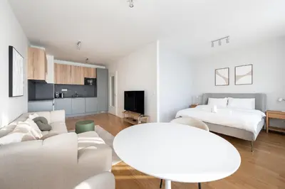 a white living room with a couch and a table at Cool All-in Apartment Prague in Prague