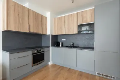 a kitchen with white cabinets and a sink at Cool All-in Apartment Prague in Prague