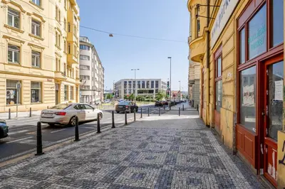 a cobblestone street in a city with buildings and cars at Blueground Letná furnished studio foodie area PRG-54 in Prague