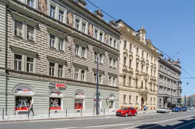 a red car parked in front of a large building at Blueground Prague 7 renovated student housing PRG-59 in Prague