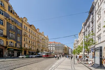 a city street with people walking and a tram at Blueground Holešovice city view nr Vltava PRG-51 in Prague