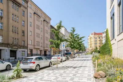 a city street with parked cars and buildings at Blueground Holešovice city view nr Vltava PRG-51 in Prague