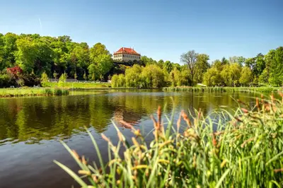 a view of a lake with a building in the background at Soukromé křídlo pro 7 osob v Praze in Prague