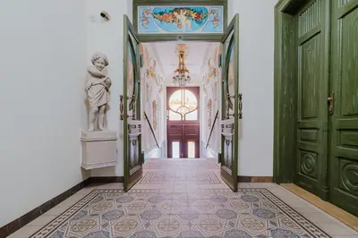 a hallway with green doors and a statue on the wall at Blueground Vinohrady balcony nr Riegrovy Sady PRG-78 in Prague