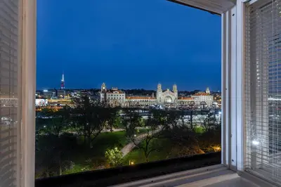 a window with a view of a city at night at Parkview Penthouse in Prague