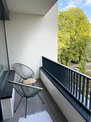 a balcony with a chair and a tree at Prague's Bohemian Grey in Prague