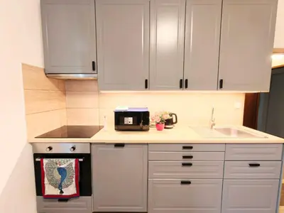 a kitchen with white cabinets and a sink at Comfy place in Prague