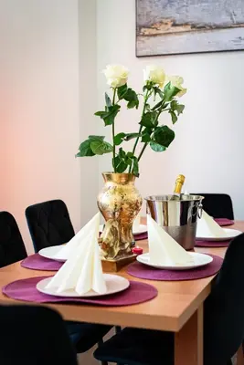 a wooden table with plates and a vase with flowers at Bohemian Emperors Residence in Prague