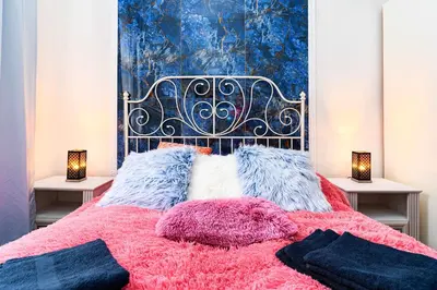 a bedroom with a bed with pink and blue at Bohemian Emperors Residence in Prague