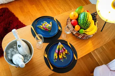 a table with plates of food and fruit on it at Bright Bohemian River in Prague