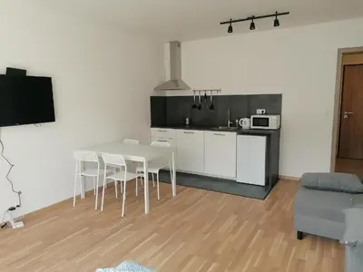 a kitchen with a table and chairs in a room at Brand new studio apartment #30 in brand new building FREE PARKING close to center in Prague
