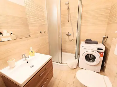 a bathroom with a sink and a washing machine at My sweet place in Prague