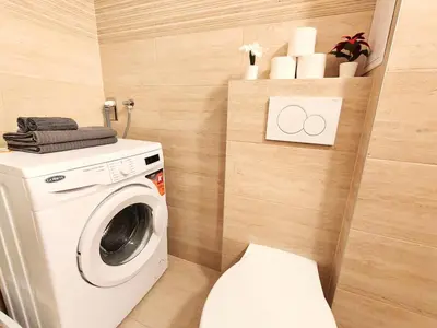 a bathroom with a washing machine and a toilet at My sweet place in Prague