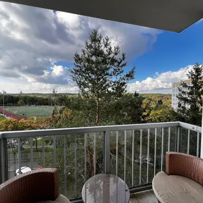 a balcony with chairs and a view of a baseball game at Big apartment in quiet location close to the center -ideal for families with kids in Prague