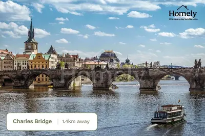 a bridge over a river with a boat at HOMELYI 28m2 Central studio with ELEVATOR and SELF CHECK-IN in Prague