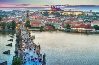 a group of people walking along a bridge over a river at 2 BR Designer Apartment in Old Town in Prague
