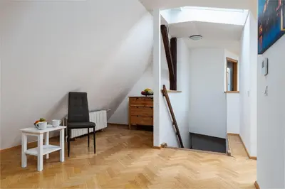 a room with a table and a chair and a staircase at Royal Skyline Penthouse in Prague