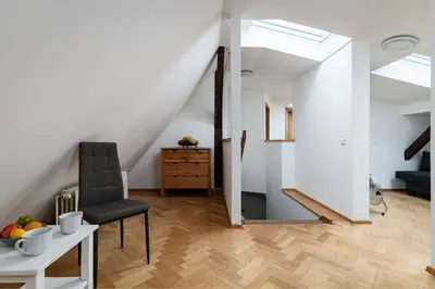 a room with a chair and a table with fruit on it at Royal Skyline Penthouse in Prague