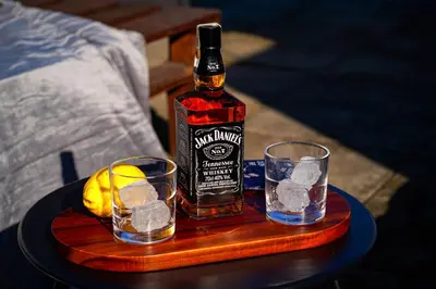 a bottle of whiskey and two glasses on a table at Crown Tiger Penthouse in Prague
