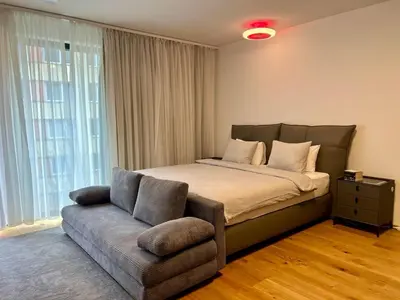 a bedroom with a bed and a couch and window at Cozy Apartments in Prague
